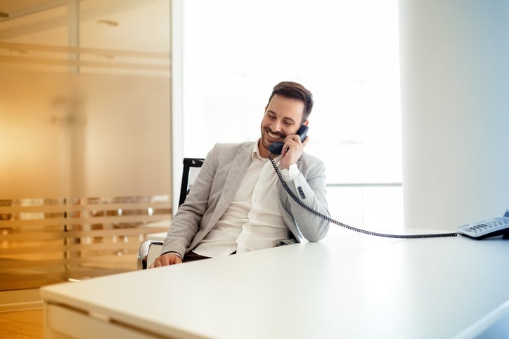 Picture of a businessman talking on a VoIP phone