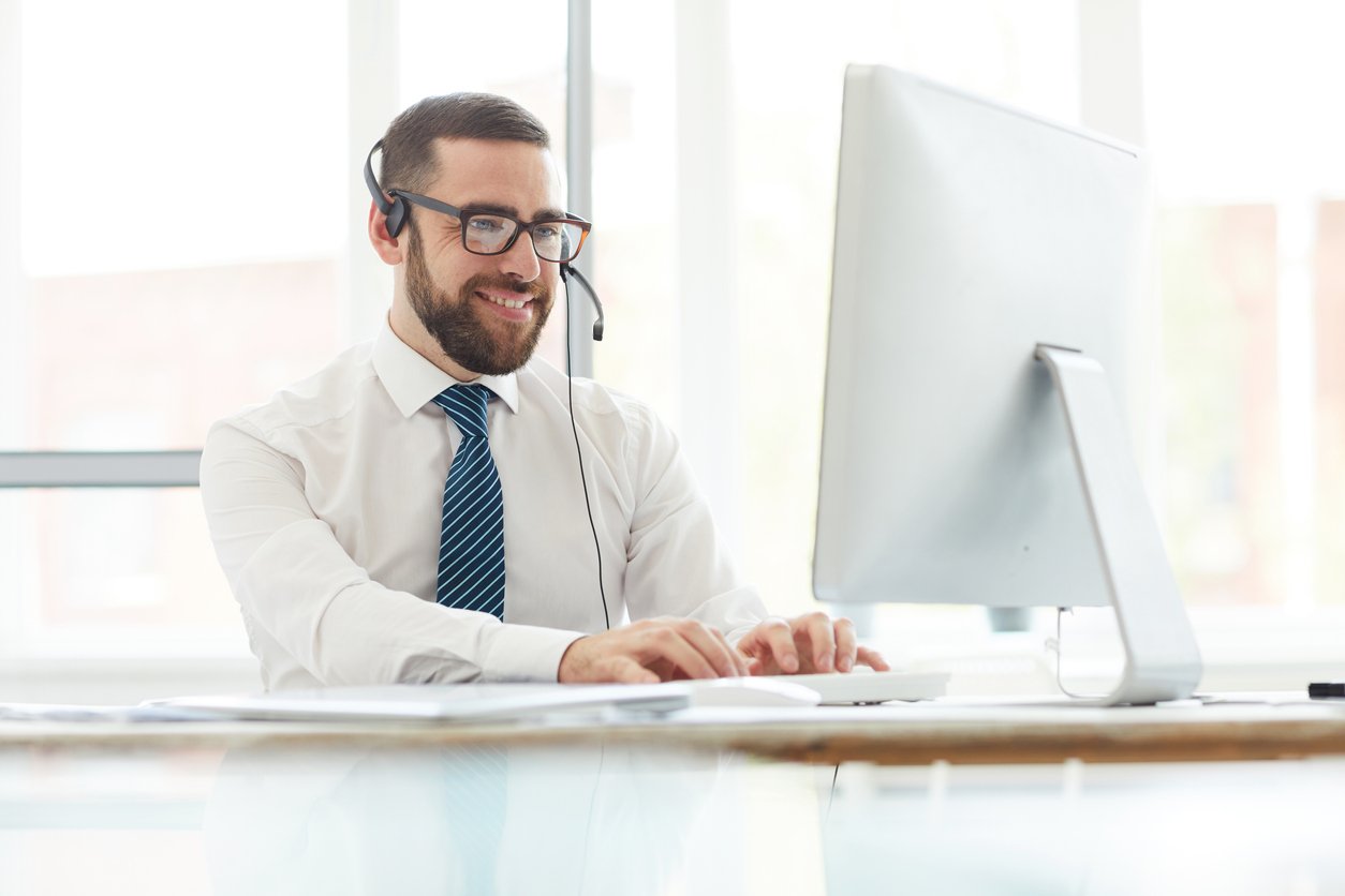 Agent on phone call in front of a computer.