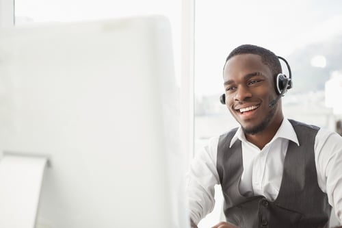 Call center employee taking a call on his headset.