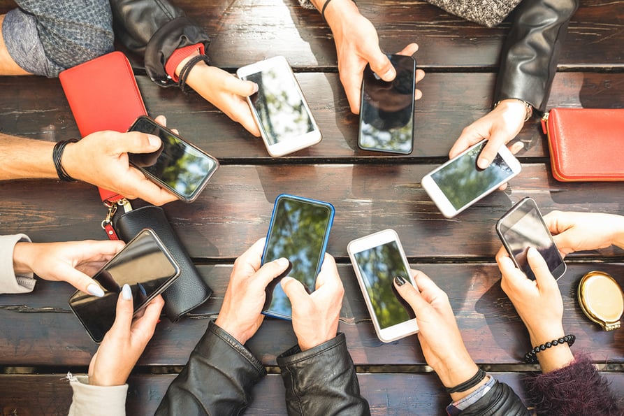 colleagues holding cell phones outdoors