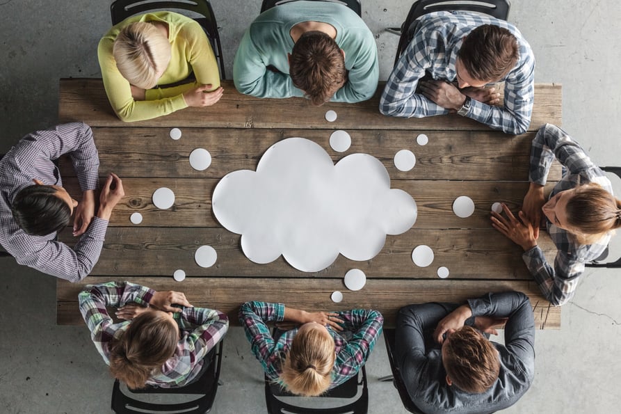 Group of people sitting around a table at a business meeting.