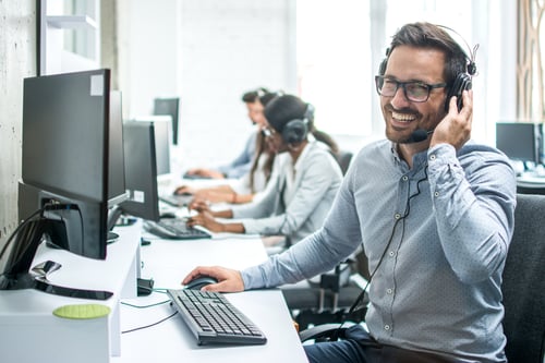 Call center employees taking calls on headsets.