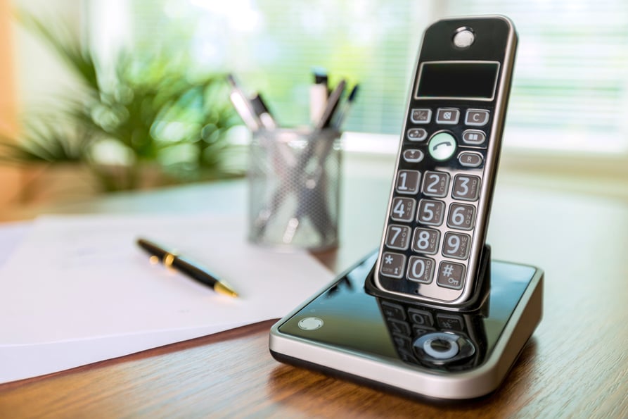 Cordless phone on a desk.