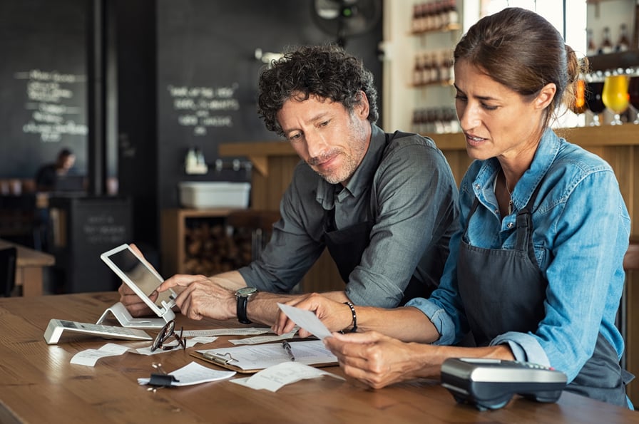 Man and woman at a table analyzing their phone bill.