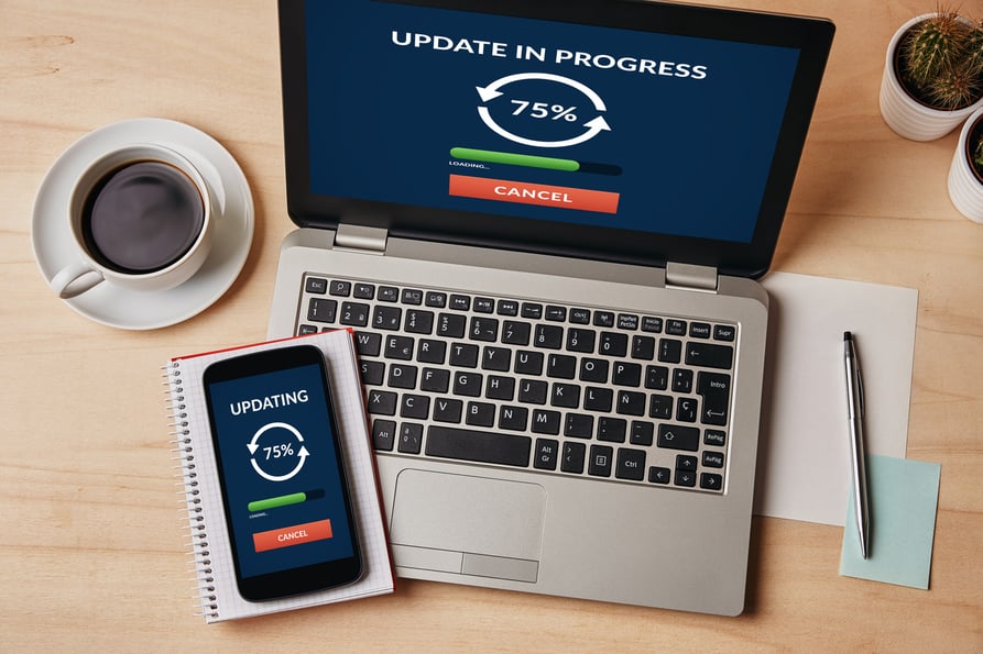 Laptop and mobile phone showing a technology update in progress.