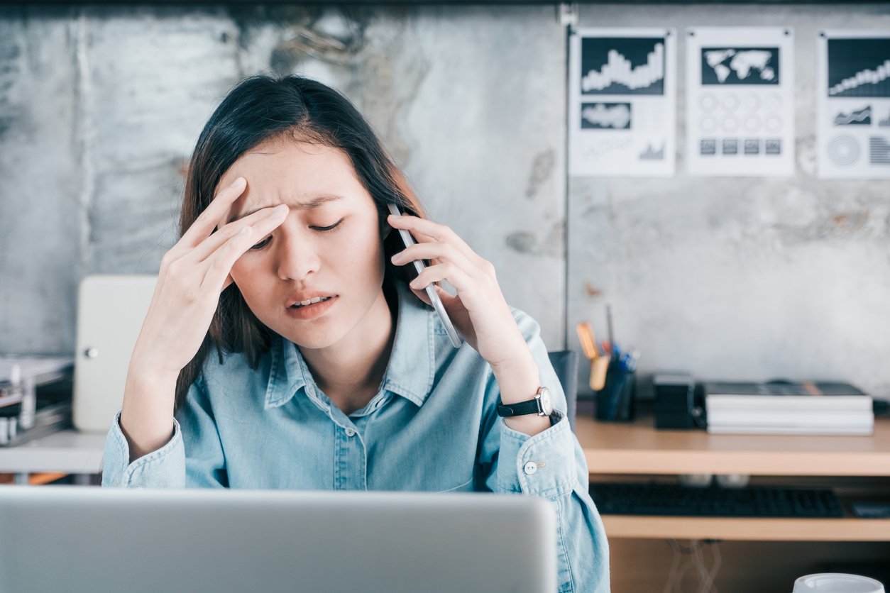 Frustrated woman making a call on her cell phone.