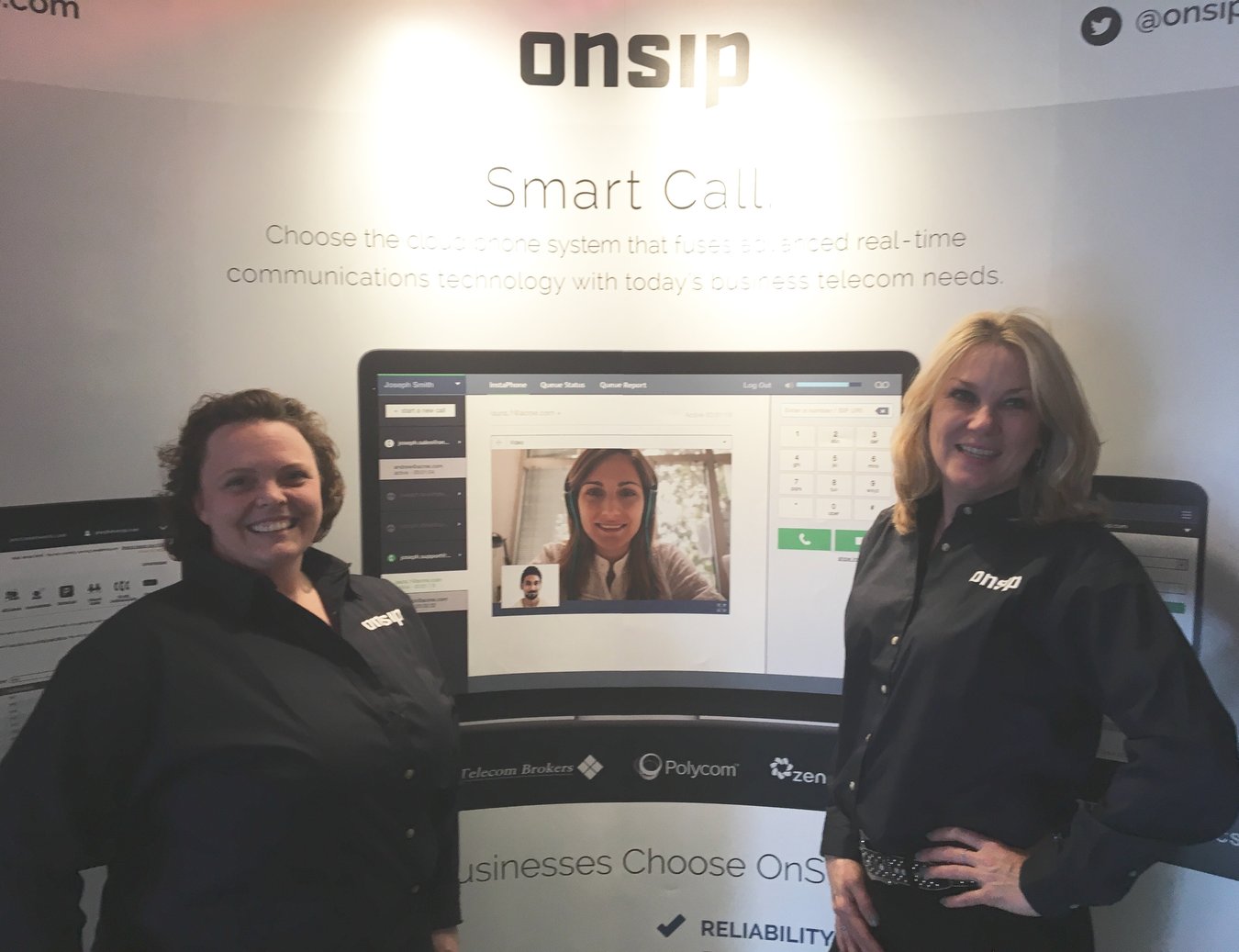 Clorece Kulp and Helene Kidary in front of OnSIP’s technology display banner