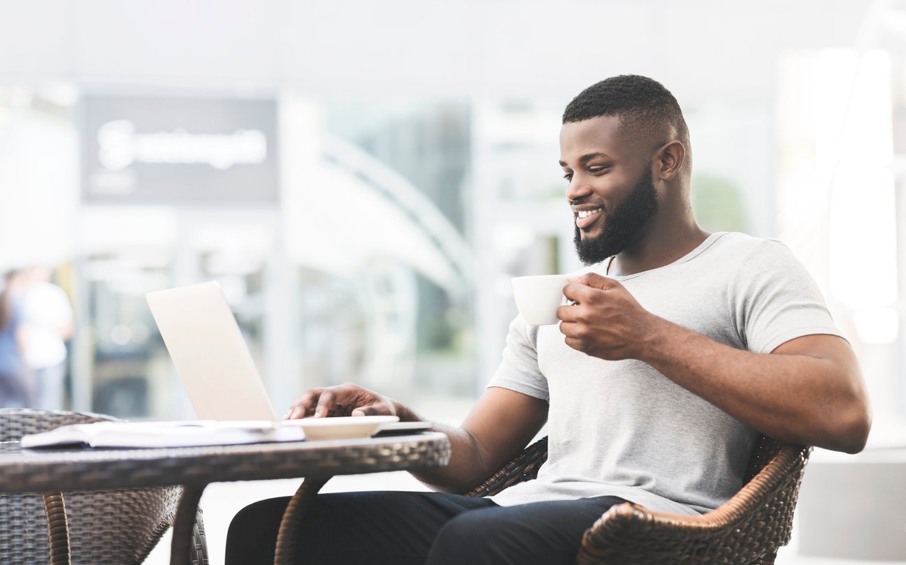 An employee taking a workcation, getting his work done at a cafe.