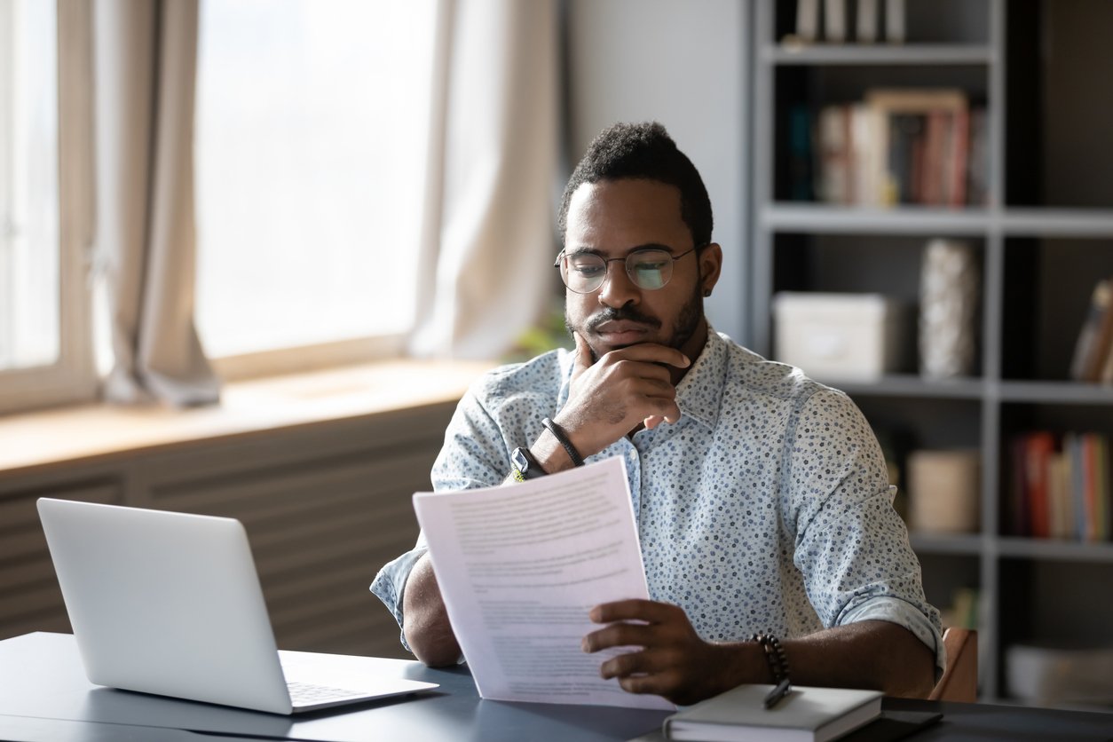 Man working from home focuses on reading a document.