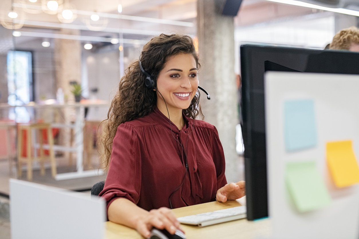 Customer service representative taking a call on a headset.