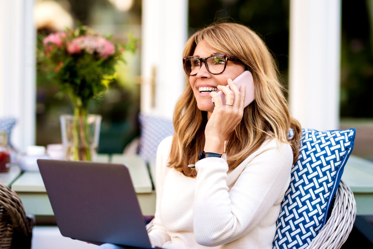 Woman on a cell phone sitting outside.