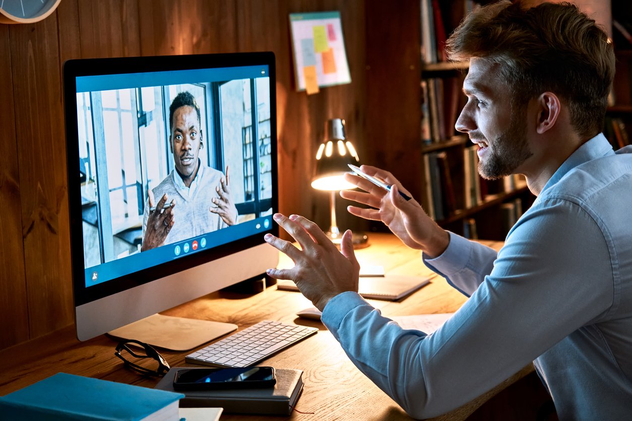 Two coworkers using hosted VoIP to video call each other.