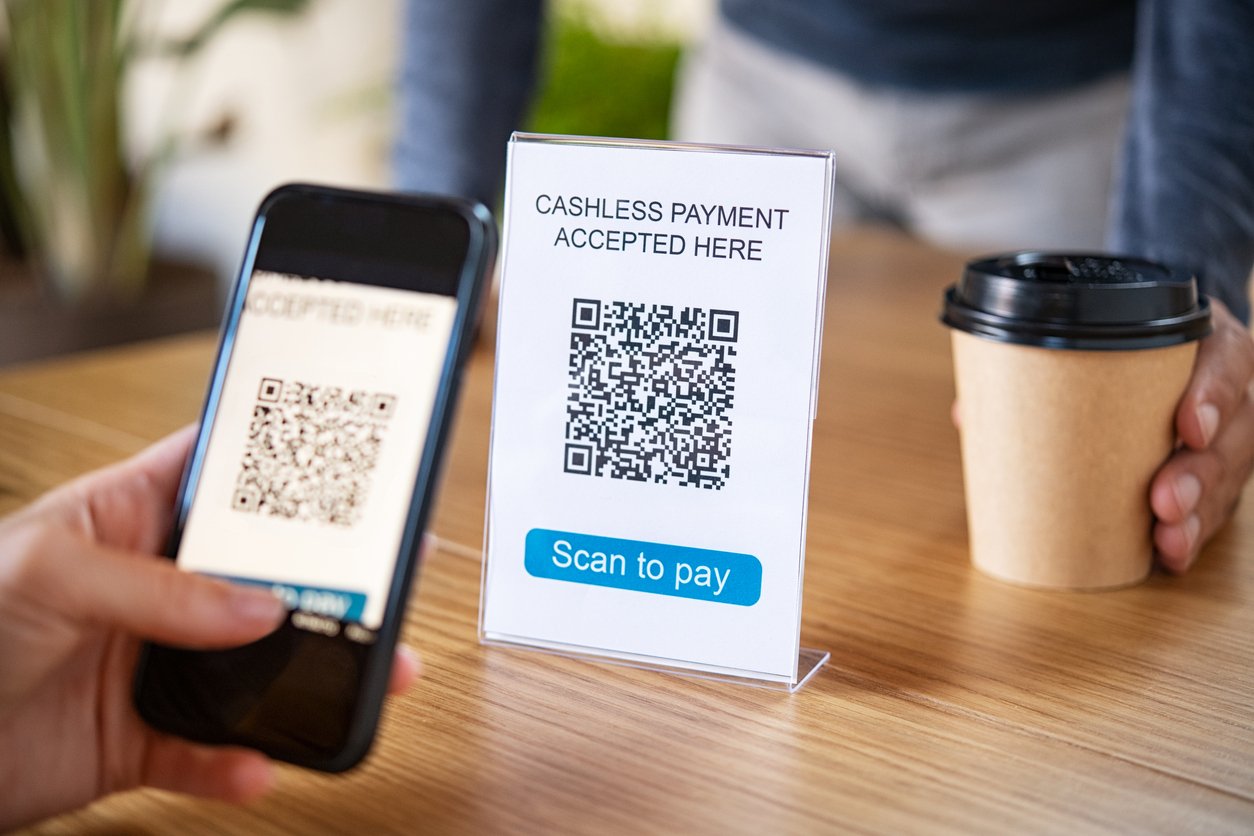 A customer scans a QR code to pay for coffee without contact.