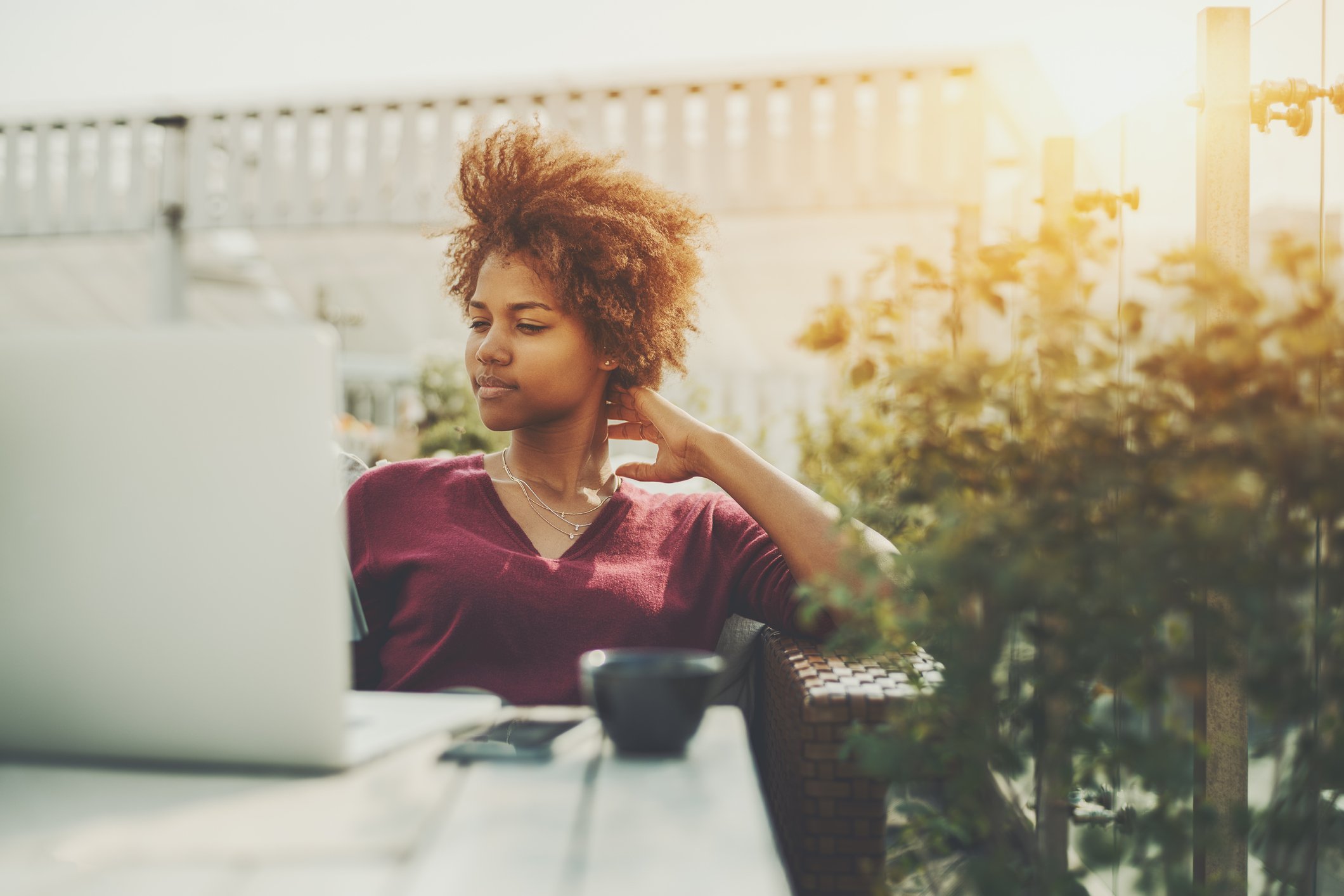 Woman sitting at a table outdoors with her laptop.