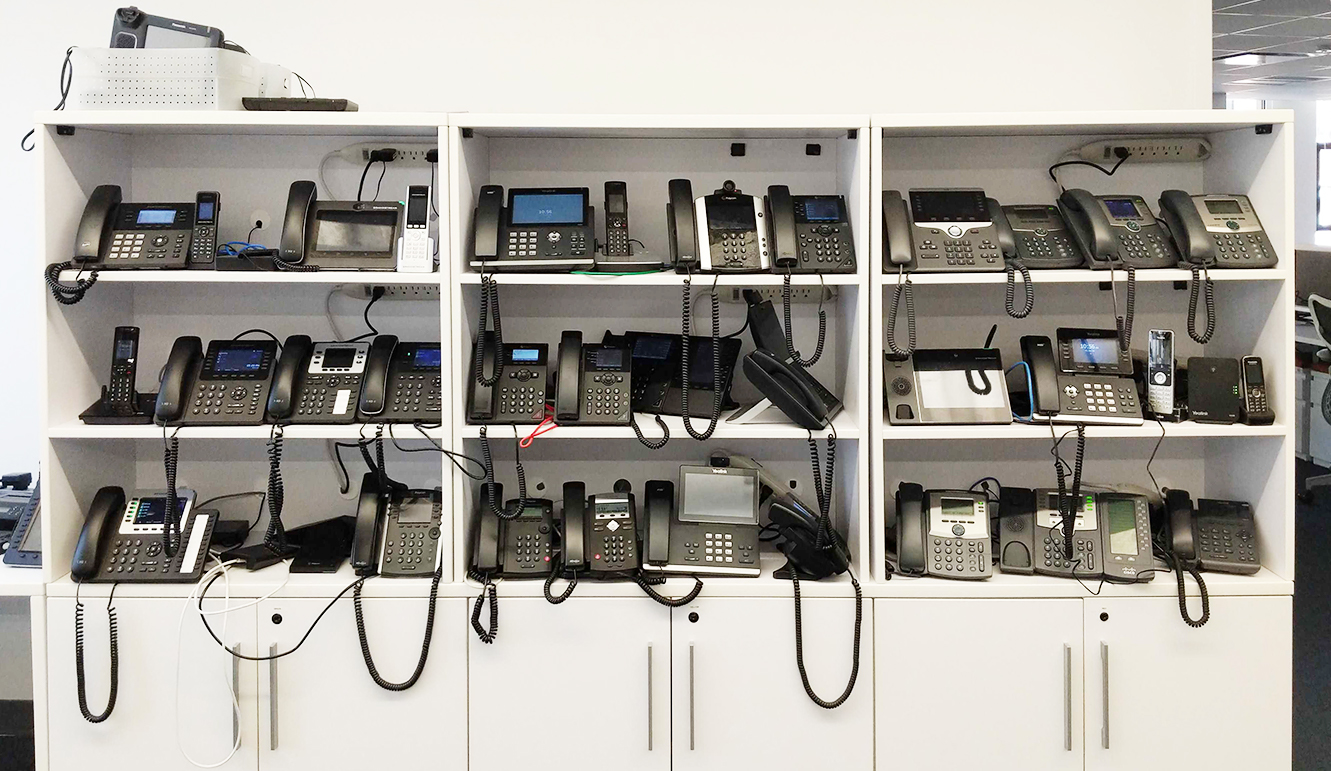 Wall of VoIP desk phones at OnSIP HQ.