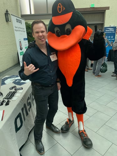 Mike Curtin posing with the Baltimore Orioles Bird mascot.