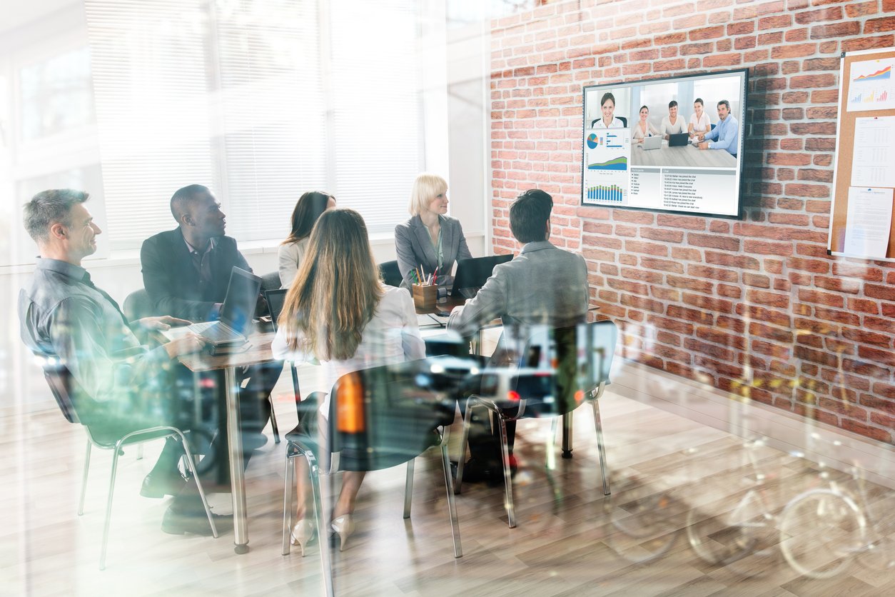 Group of business colleagues in an office participating in a group video conference call.